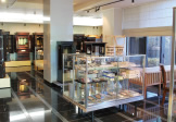 店内の展示。ガラスケースの仏具と、奥に並ぶお仏壇